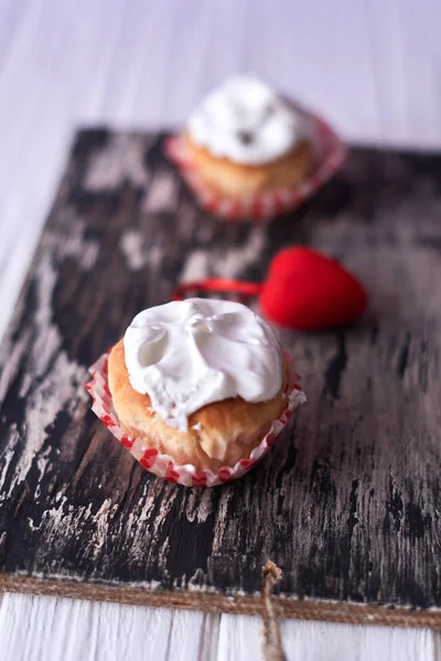 Pasteles con crema blanca sobre fondo de madera —  Fotos de Stock