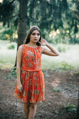 Kırmızı bir yaz aylarında güzel genç kız elbise bir parkta