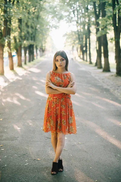 Belle jeune fille dans une robe rouge d'été dans un parc — Photo