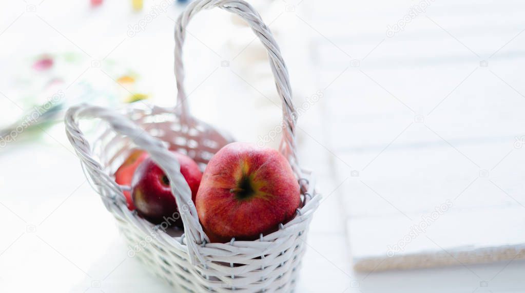 Red fresh apples in a white wooden basket