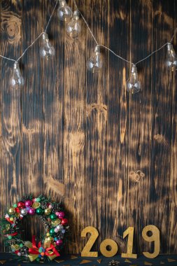 Noel çelenk ahşap koyu arka plan üzerinde altın sayılarla 2019