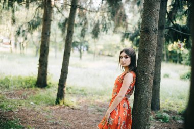 Kırmızı bir yaz aylarında güzel genç kız elbise bir parkta