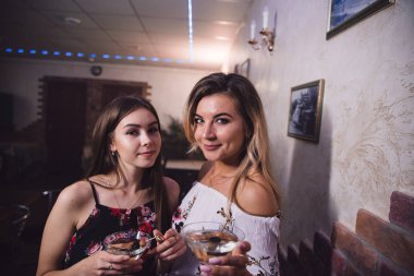 Kızlar arka plan bulanık ile kokteyller ile bir bar.