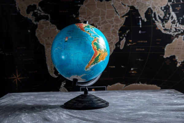 Globo geográfico en el fondo de un mapa del mundo negro — Foto de Stock