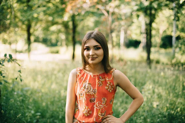 Kırmızı bir yaz aylarında güzel genç kız elbise bir parkta — Stok fotoğraf