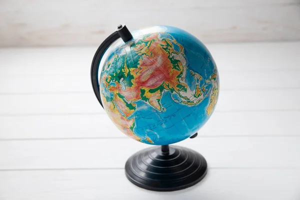 Globe on white wooden boards with space for text — Stock Photo, Image