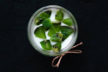 Kivi dilimleri siyah bir arka plan ile yoğurt