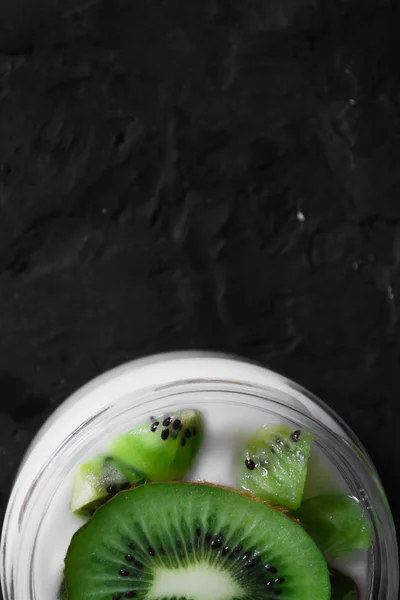 Yogurt with kiwi slices on a black background — Stock Photo, Image