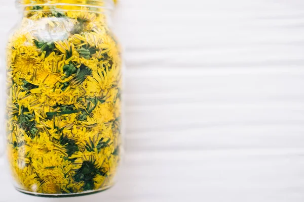 Dandelions beyaz bir arka plan üzerinde cam kavanozda