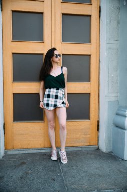 bina tarafından poz güneş gözlüğü genç kadın