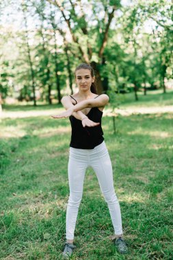 Genç güzel kız parkta egzersizleri yapıyor