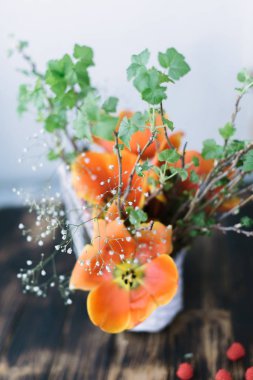 Ahşap arka plan üzerinde bir sepet içinde çiçek açan laleler