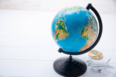 Küçük düzlem modeli ile beyaz ahşap arka plan üzerinde küre