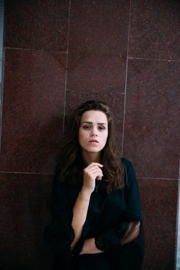 Kahverengi bir duvara yakın yeşil bir elbise genç kız