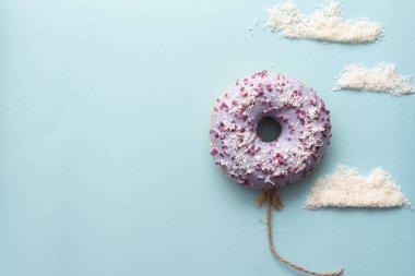 Kavram mor donuts bulutlar minimalizm ile mavi bir arka plan üzerinde
