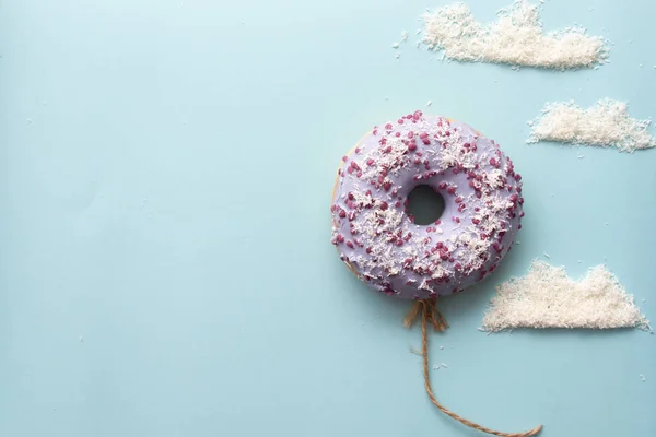 Kavram mor donuts bulutlar minimalizm ile mavi bir arka plan üzerinde