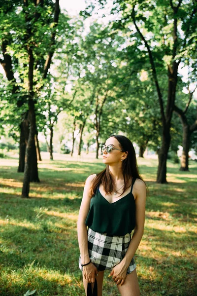 Menina bonita em um parque em óculos de sol — Fotografia de Stock