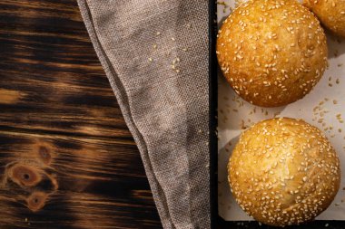 Ahşap arka planda çuval üzerinde ev yapımı çörekler