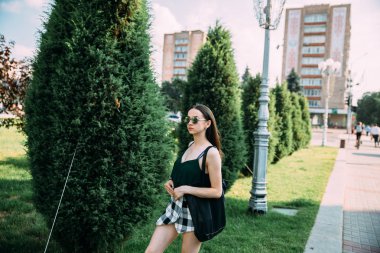 Esmer kız bir yaz günü içinde yuvarlak güneş gözlüğü takıyor