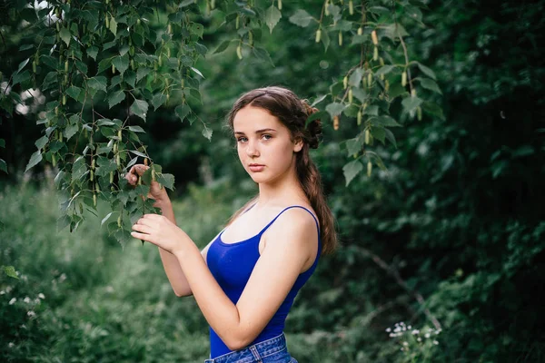 Krásná dívka v krátkých šortkách a modré tričko v lese — Stock fotografie