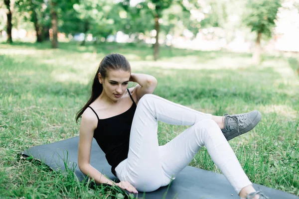 Młoda piękna dziewczyna robi jogi na świeżym powietrzu w parku — Zdjęcie stockowe