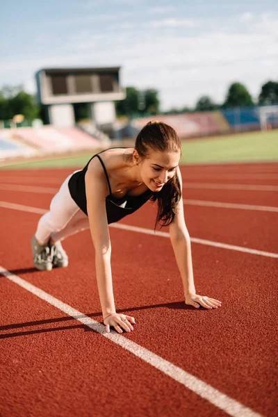 Girl athlete wrung out on the field on a sunny day