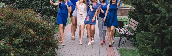 Meninas em azul caminhar ao longo da pista em uma festa de despedida de solteira — Fotografia de Stock