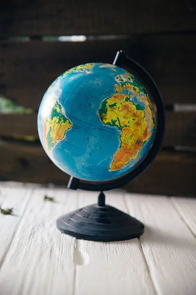 Globe on wooden white boards with a blurred background. Autumn still life — Stock Photo, Image