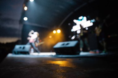Konser odak dışı. Bulanık arkaplanda sahne sanatçıları