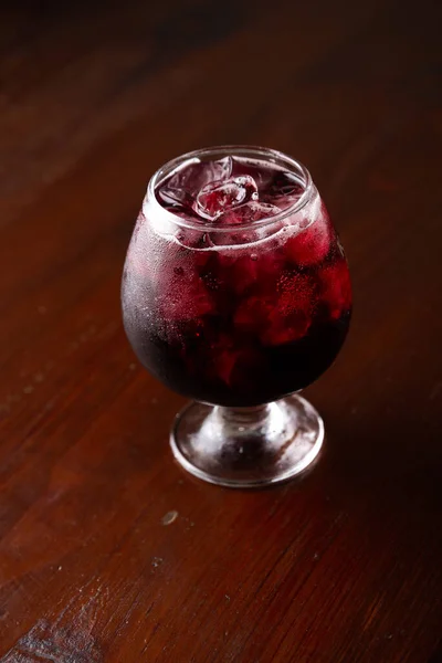 Cocktail in ice bar on blurred wooden background — Stock Photo, Image