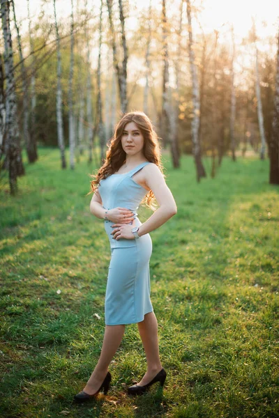 Vacker ung flicka i blå klänning i en vårpark — Stockfoto