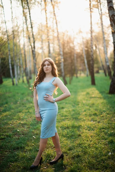 Schöne junge Mädchen in einem blauen Kleid in einem Frühlingspark — Stockfoto