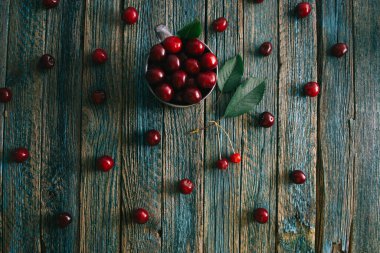 Çelik bardaktaki kirazlar ahşap bir arka planda