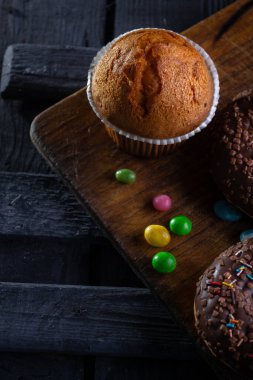 Ahşap tahta üzerinde çörekler, mavi beton arka planda.