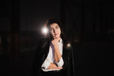 Terk edilmiş bir şantiyede deri ceketli bir kız.