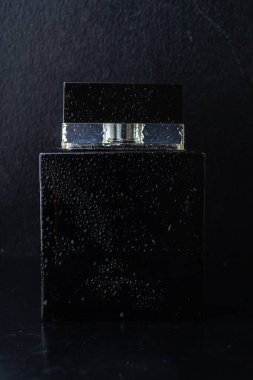 Siyah erkek parfümü koyu bir arka planda