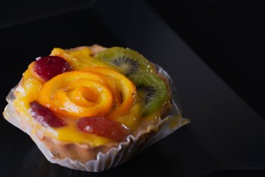 Siyah arka planda turuncu peynirli tatlı.