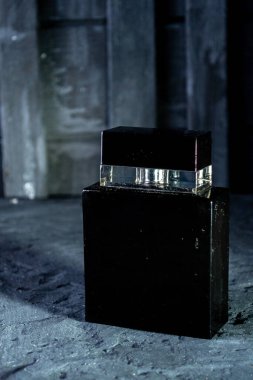 Siyah erkek parfümü koyu bir arka planda