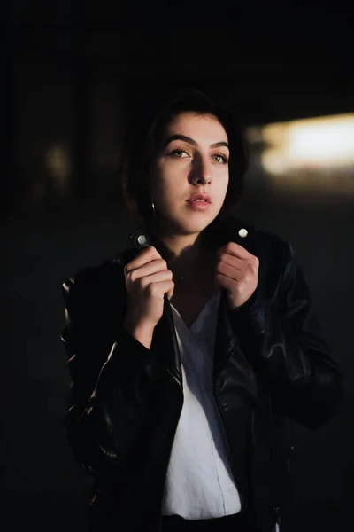 Girl in a leather jacket on an old abandoned construction site — Stock Photo, Image