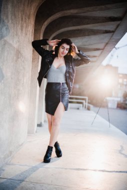 Esmer kız bir yaz öğleden sonra akşam kentinde yürüyor.