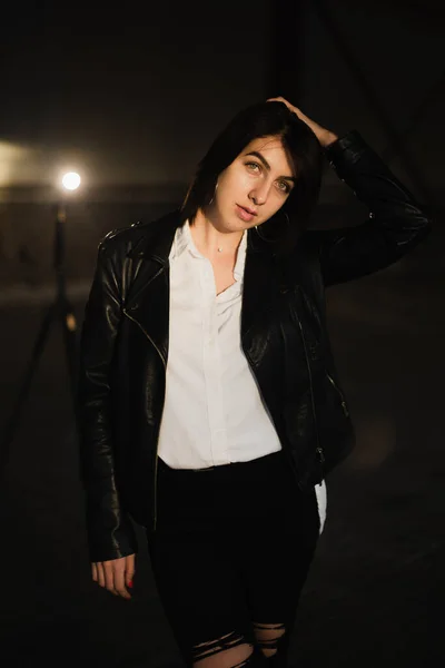 Girl in a leather jacket on an old abandoned construction site — Stock Photo, Image