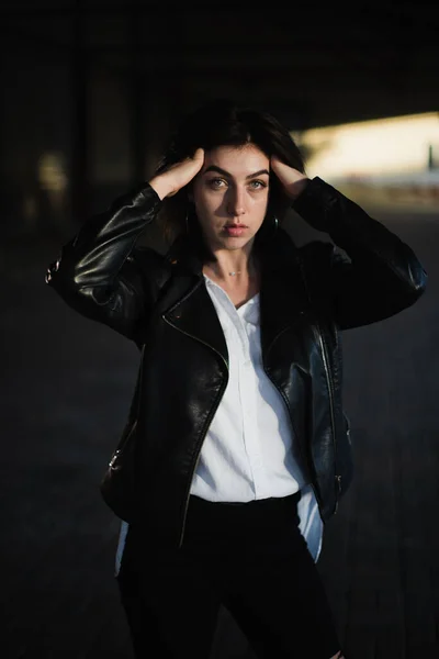 Girl in a leather jacket on an old abandoned construction site — Stock Photo, Image