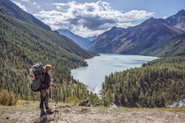 Bir dağ manzarasının arka planında, Belukha Dağı, Altai 'de gezinen bir turist kız.