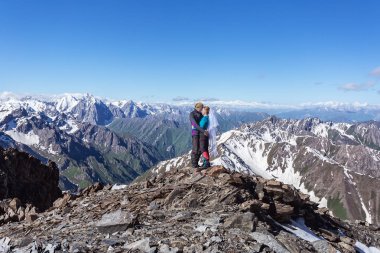 Kırgızistan Yazı. Dağın tepesinde buzdan bir baltayla dolaşan çiftler. Dağlara tırmanıyor..