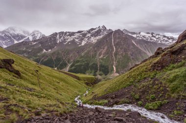 Elbrus 'un dağlık bölgesi, Avrupa' nın en yüksek noktası. Dağlar ve buzullarla kaplı bir manzara. Dinlenmek için dağlara yürüyün..