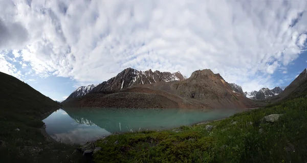 Mavi nehir manzarası ve Tien Shan dağlarının karlı tepeleri baharda güneşli bir günde. 