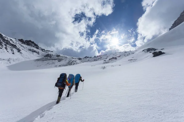 吉尔吉斯斯坦 一群带着背包在山坡上远足的游客 — 图库照片