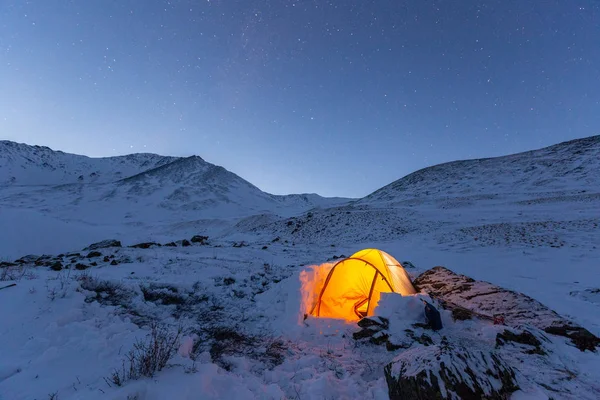 night sky over Belukha Mountain. Tent in the snow in the winter on the mountain elephants