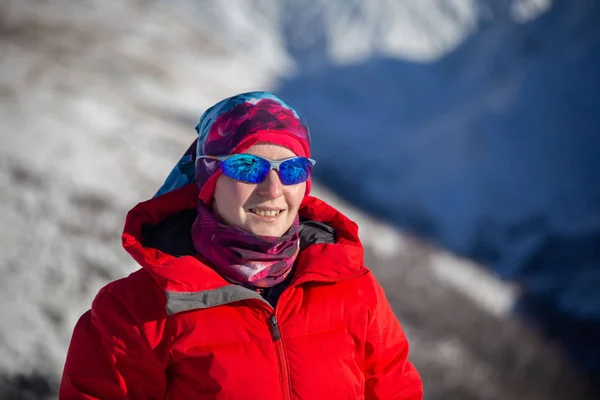 traveler in warm sporty clothes hiking in snowy mountains at sunny winter day