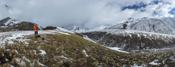 Male hiker in warm sporty clothes hiking in mountains